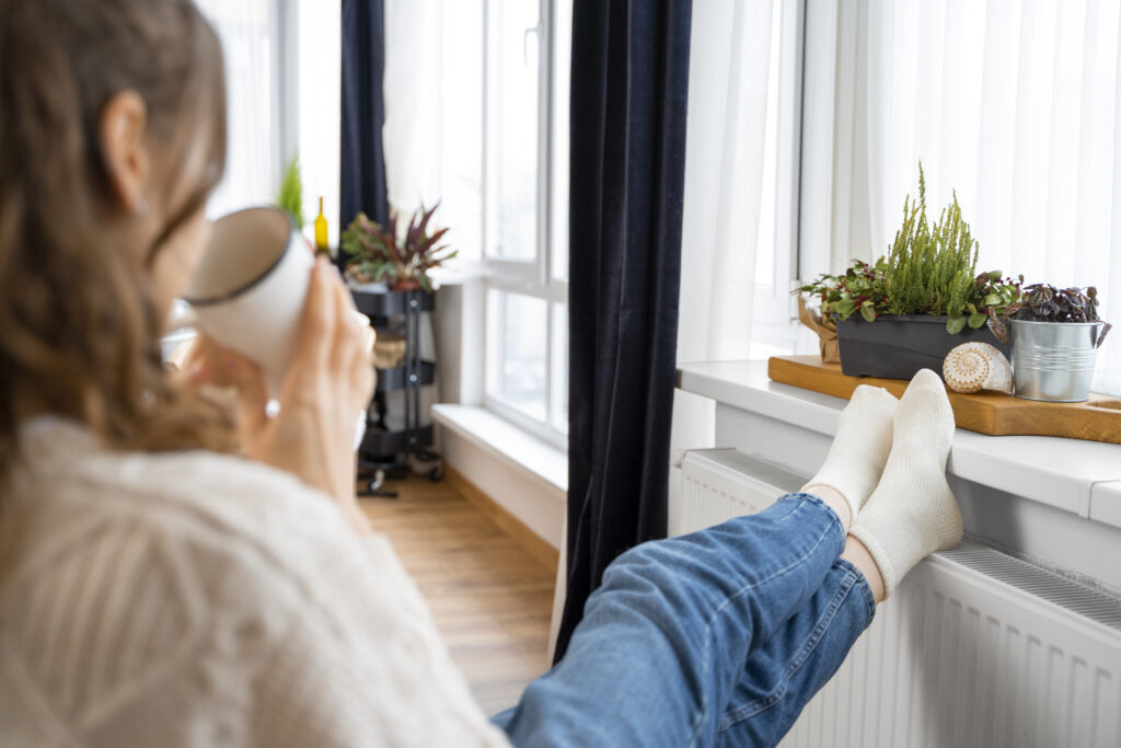 A woman enjoys a cup of tea near the windows in her Atlanta home.