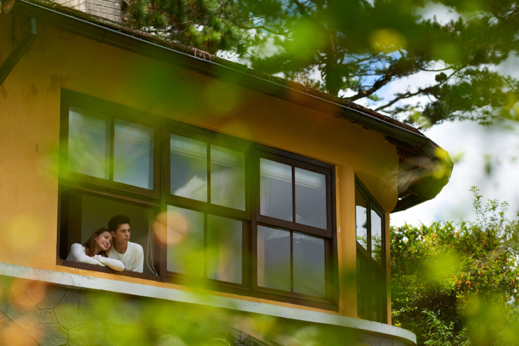 Couple gazes out the window of their Atlanta home, symbolizing the peace of mind provided by Top Notch's installation of their windows and doors.