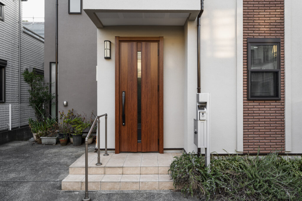 Home entrance with a wooden door, representing the importance of hiring a door and window installation company that offers quality service.