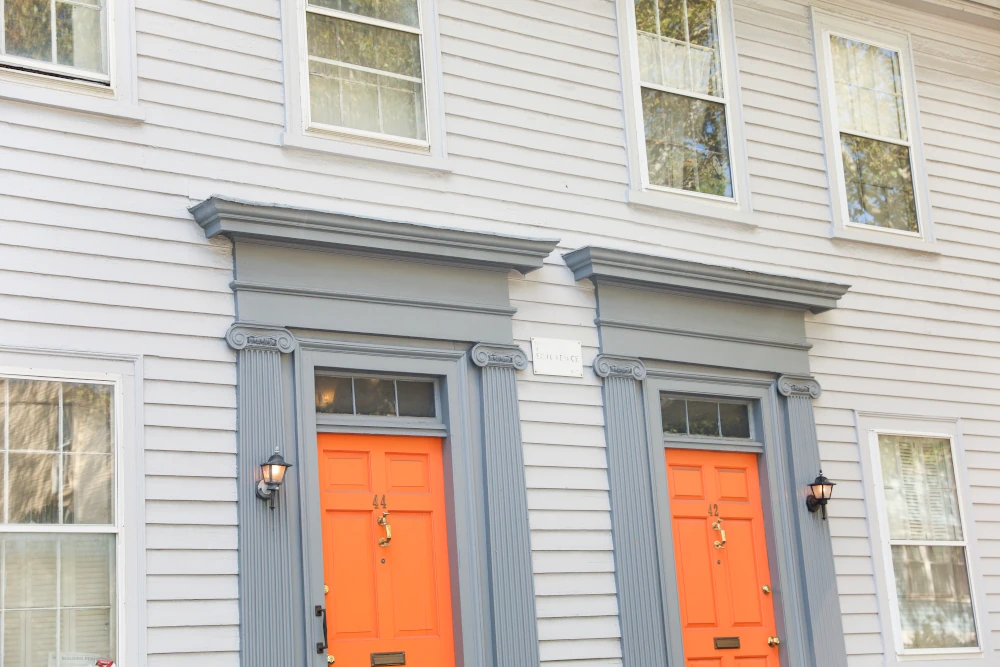 Houses with orange doors and glass windows symbolizing the importance of a quality window and door installation.