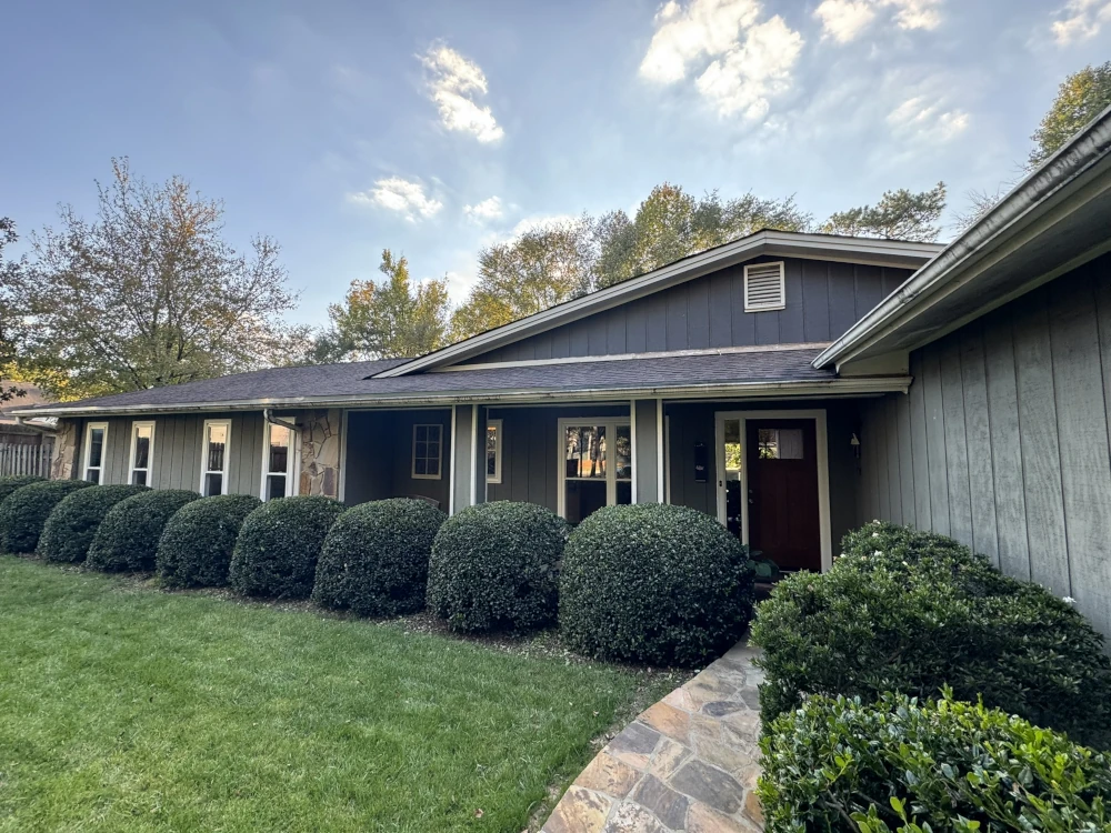 A house with wooden doors and glass windows, the result of a project by Top Notch, a leading door and window installation company.