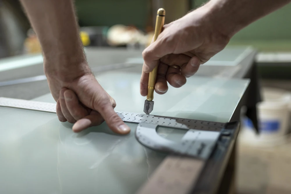 A worker cutting material in a factory, representing the importance of choosing customized doors and windows.