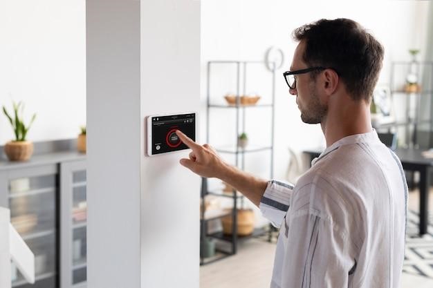 A man using a feature of his smart home to control the doors and windows.