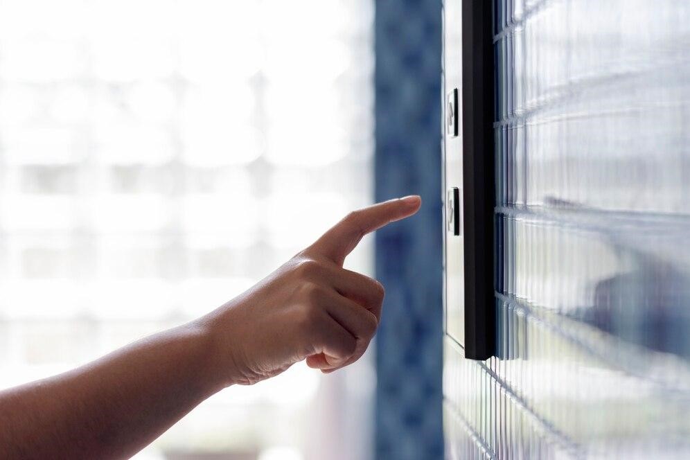 Woman pressing a button in her home and activating the smart features of her doors and windows.