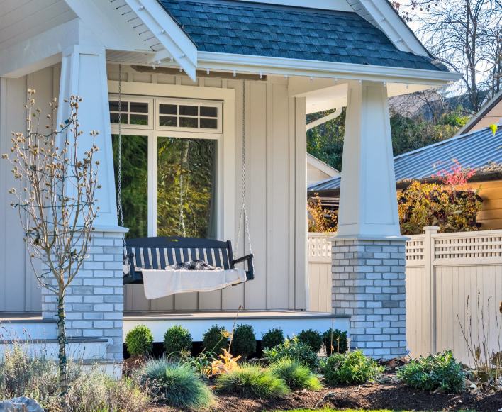 A luxury family home featuring a swinging bench in an open patio, showcasing a facade that remains unchanged due to the lack of permission to change window to door.