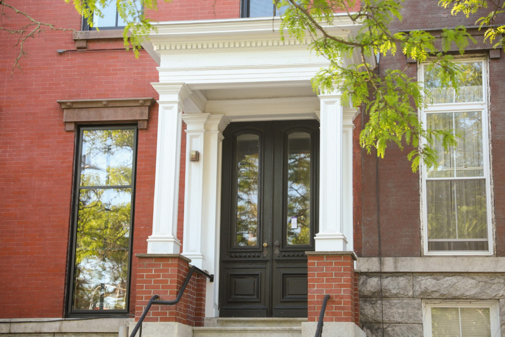 Red brick building with a black entry door.