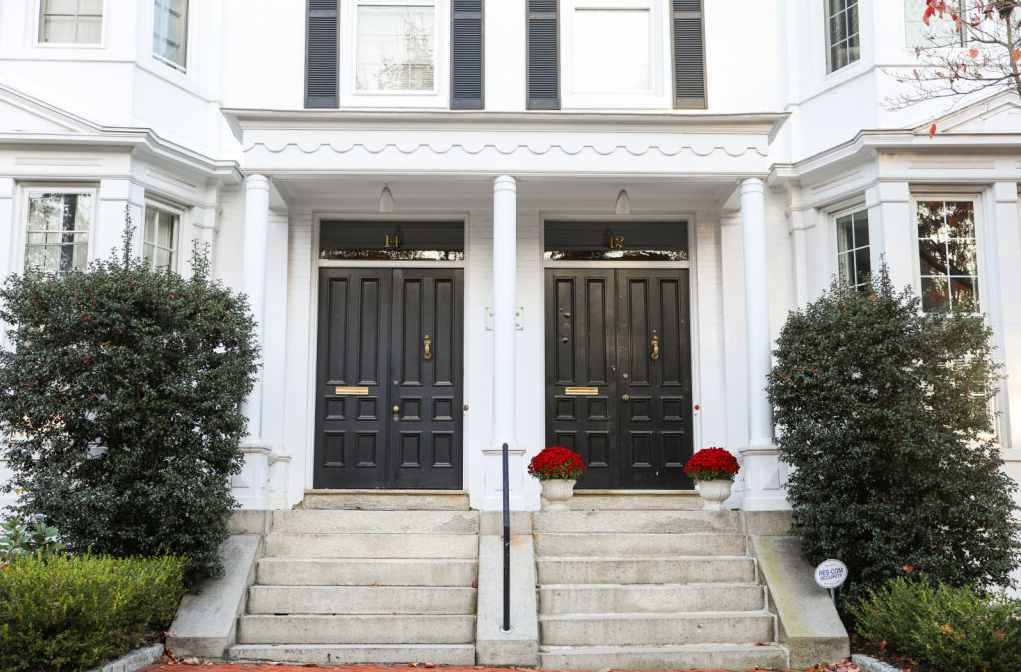 White North American house with some plants and two personalized entry doors.