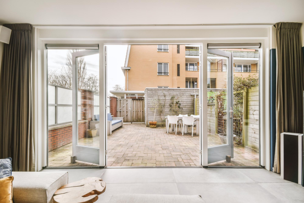 View of an open hinged door for the outdoor area of a residential space, showing the importance of choosing between sliding doors vs hinged doors.