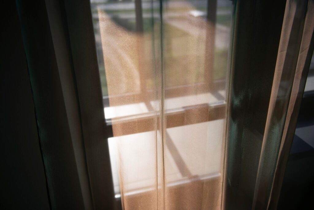 Curtain covering a window glass, showing the importance of combining materials between the various types of glass for windows.