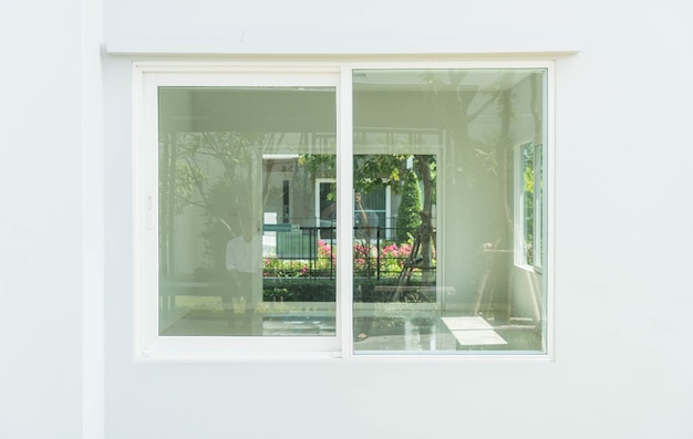 Glass windows show the interior of an empty room, representing the importance of choosing the right material among the various types of glass for windows.