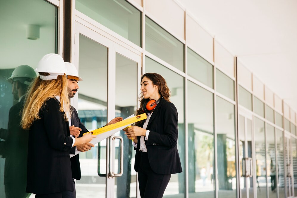 Three people leaning against a building façade, analyzing energy-efficient window certifications.