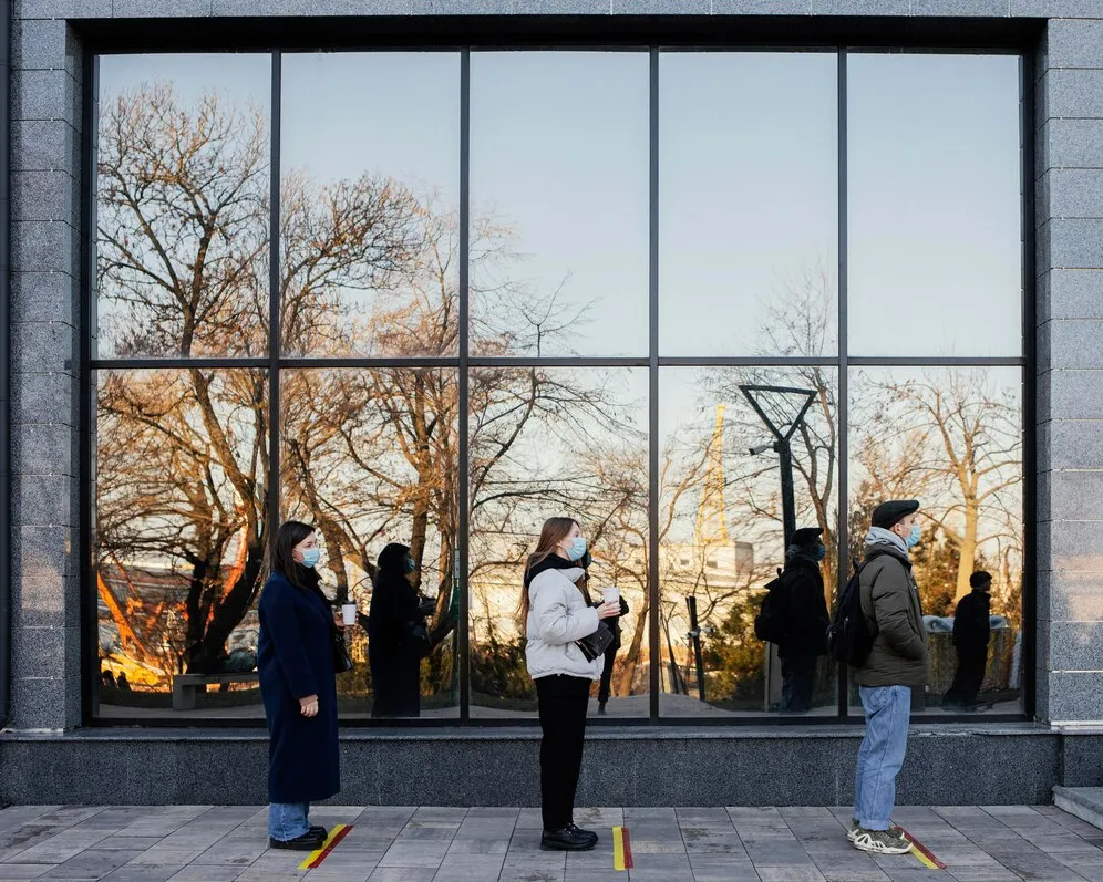 People in a line waiting to be assisted at an institution with high-quality commercial windows and doors